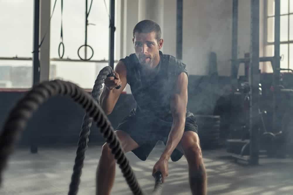 athletic man doing rope exercise for stamina training