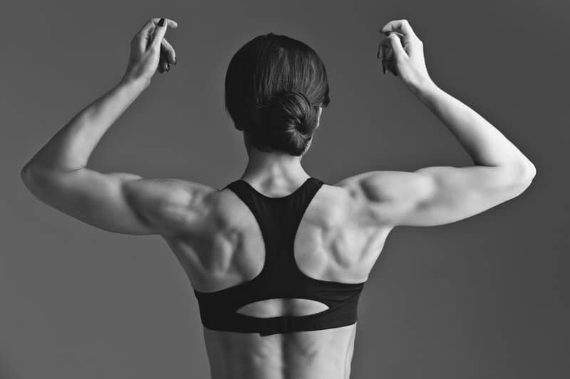 athletic woman flexing back muscles